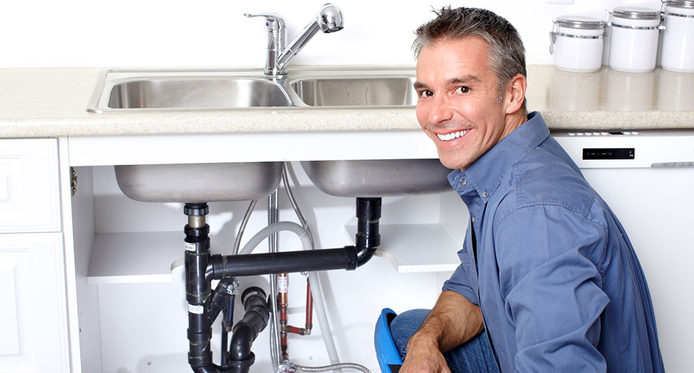 Man smiling with faucet in background