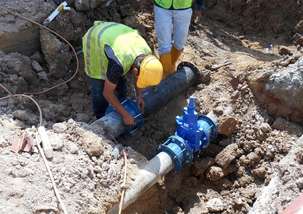 Man fixing sewage pipe